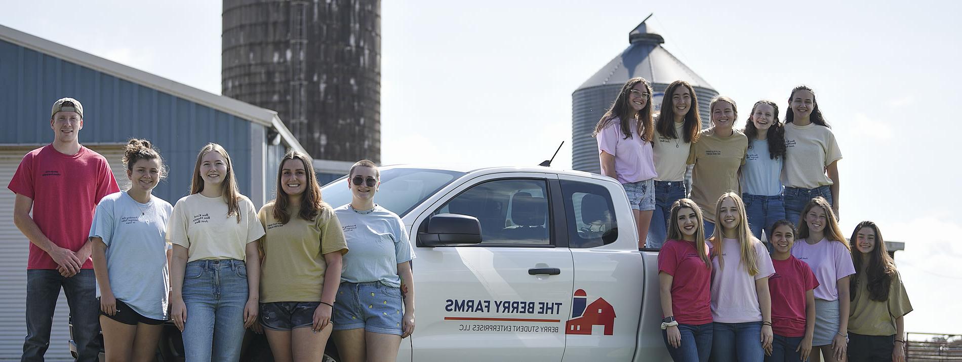 一群浆果农场的团队成员站在蓝色科技谷仓的浆果农场卡车里和周围
